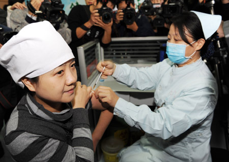 Sun Yan (L), a doctor of Zhengzhou No.6 People's Hospital, receives the A/H1N1 influenza vaccination in Zhengzhou, capital of central China's Henan Province, October 31, 2009. A vaccination program against the A/H1N1 virus is kicked off in the province on Saturday. 