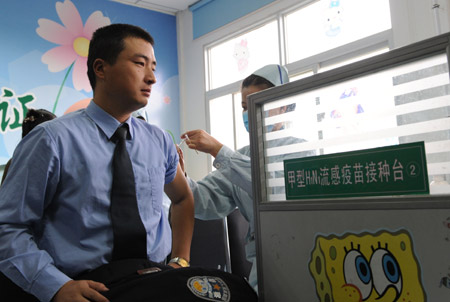 A police receives the A/H1N1 influenza vaccination at Zhengzhou No.6 People's Hospital in Zhengzhou, capital of central China's Henan Province, October 31, 2009.