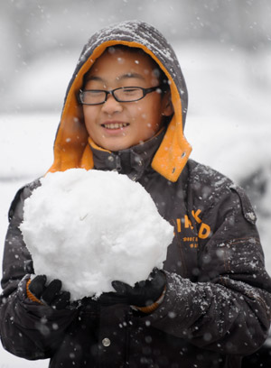 A boy holds a snowball in Beijing November 1, 2009.