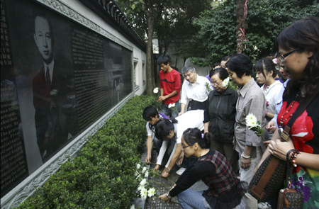 Local residents of Xiaoying Alley lay the white chrisanthemum to mourn for the just passed-away China's keystone space scientist Qian Xuesen, in front of his portrait on a stone tablet in his hometown of Hangzhou, east China's Zhejiang Province, October 31, 2009. 