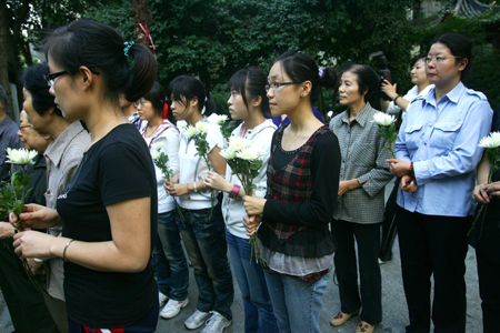 Local residents of Xiaoying Alley holding the white chrisanthemum mourn in grief for the just passed-away China's keystone space scientist Qian Xuesen in front of his portrait on a stone tablet in his hometown of Hangzhou, east China's Zhejiang Province, October 31, 2009.
