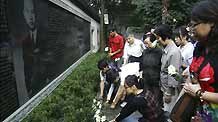 Local residents of Xiaoying Alley lay the white chrisanthemum to mourn for the just passed-away China's keystone space scientist Qian Xuesen, in front of his portrait on a stone tablet in his hometown of Hangzhou, east China's Zhejiang Province, October 31, 2009.