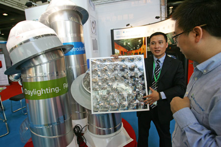 An exhibitor introduces to a visitor a sunlight lightening system that can lead sunlight into a room through pipe at the 2009 Hangzhou International Recycling Economy and Environmental Industry Expo of China in Hangzhou, east China's Zhejiang Province, October 31, 2009.
