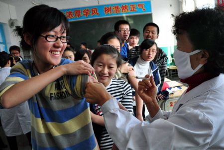 Students get the A/H1N1 influenza vaccination in turns from medical staff with local center for disease control and prevention, at Dongning County, northeast China's Heilongjiang Province, October 28, 2009. China steps up nationwide vaccination programs with its maximal capacity to supply its domestic population with influenza vaccines.