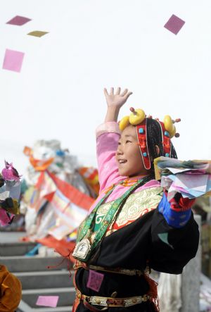 Ceyun Bainco throws up fengma, the colorful paper scrips for prayer, in Hol Xil Natural Reserve in Northwest China's Qinghai Province, October 23, 2009. 