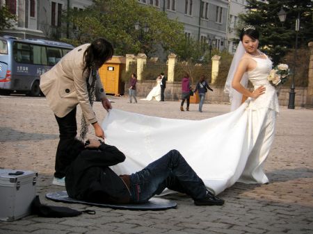 Photo taken by Ren Houshu on October 24, 2009 shows that a cameraman takes photos of a bride in Qingdao, a coastal city in east China's Shandong Province.