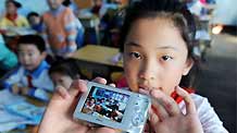 Ren Houshu shows her camera at Jilin Road Elementary School in Qingdao, a coastal city in east China's Shandong Province, October 26, 2009.