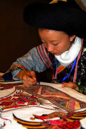A woman of the Miao ethnic group extemporizes a batik brocade with beautiful patterns, on the 2009 'Colorful Guizhou' Tourist Commodities Design Competition and Final Selection Campaign of Skillful Craftsmen in Designing Tourist Commodities, in Guiyang, southwest China's Guizhou Province, November 3, 2009. 