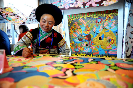 A woman of the Miao ethnic group extemporizes a brush painting, on the 2009 'Colorful Guizhou' Tourist Commodities Design Competition and Final Selection Campaign of Skillful Craftsmen in Designing Tourist Commodities, in Guiyang, southwest China's Guizhou Province, November 3, 2009.