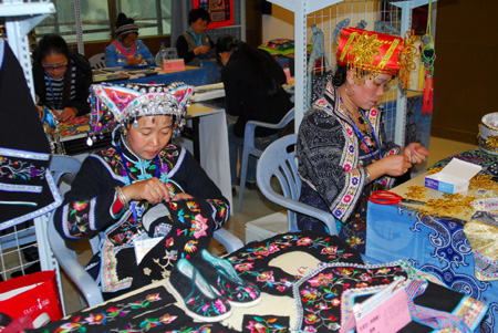 Contestants are engrossed in stitchwork for exquisite embroidery on the 2009 'Colorful Guizhou' Tourist Commodities Design Competition and Final Selection Campaign of Skillful Craftsmen in Designing Tourist Commodities, in Guiyang, southwest China's Guizhou Province, November 3, 2009.