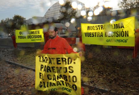 A Greenpeace activist displays a banner during a demonstration outside the venue of the UN 2009 5th Climate Change Talks in Barcelona, Spain, November 5, 2009. 
