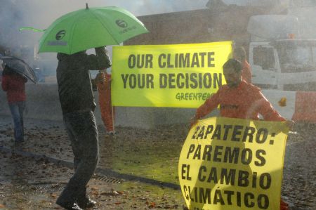 A Greenpeace activist displays a banner during a demonstration outside the venue of the UN 2009 5th Climate Change Talks in Barcelona, Spain, November 5, 2009.
