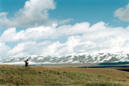 A Tibetan woman takes her child to school sponsored by Hope Project from Layihai village, Daotanghe town, Gonghe County, northwest China's Qinghai Province, in April 1999. Over 90 percent children in this village go to school since the boarding school was built in 1990's.