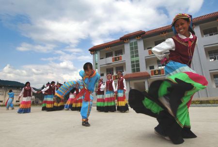 Students of Yi nationality dance at a local Hope Primary School in Mianning County, southwest China's Sichuan Province, June 20, 2006.