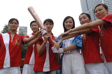 Su Mingjuan (3rd L), whose portrait was regarded as the public image of Hope Project, displays the torch of 2008 Beijing Olympics during a torchbearer selective trial in Hefei, capial of east China's Anhui Province, July 7, 2007.