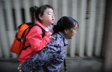 Song Xinyi's grandma (R) picks her up from kindergarten in Chengdu, capital city of southwest China's Sichuan Province, on Oct. 26, 2009.