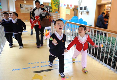 Song Xinyi (R) walks hand in hand with a boy in kindergarten in Chengdu, capital city of southwest China's Sichuan Province, on October 26, 2009.