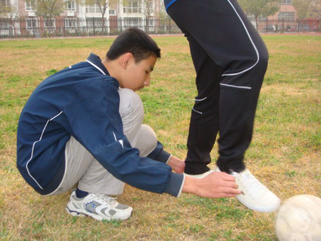 Photo taken by Zhao Congrui shows Li Zheng, a visually-impaired boy, learns to dribble the ball by touching a teacher's foot in Tianjin School for the Visually Impaired in Tianjin, north China, October 28, 2009. 