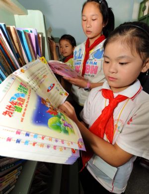 Xie Yuxing (R), a 10-year-old deaf and dumb girl from the mountainous region in northern Fujian Province, reads the extracurricular books, in Nanping, southeast China's Fujian Province, October 29, 2009.