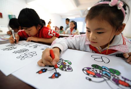 Xie Yuxing (R), a 10-year-old deaf and dumb girl from the mountainous region in northern Fujian Province, draws patterns on the art lesson, in Nanping, southeast China's Fujian Province, October 29, 2009.