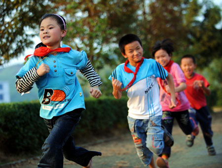 Xie Yuxin (1st L), a 10-year-old deaf and dumb girl from the mountainous region in northern Fujian Province, runs on the playground on campus, in Nanping, southeast China's Fujian Province, October 29, 2009.