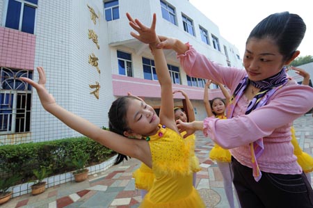 Xie Yuxin (L), a 10-year-old deaf and dumb girl from the mountainous region in northern Fujian Province, learns dancing on the dance lesson, in Nanping, southeast China's Fujian Province, October 29, 2009.