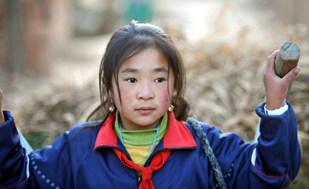 Hai Qin, a 12-year-old girl of Hui ethnic group, helps with housework after class in Kaicheng Town of Guyuan City, northwest China&apos;s Ningxia Hui Autonomous Region, Oct. 22, 2009.
