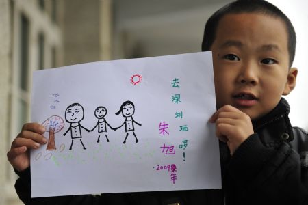 Zhu Xu shows his drawing which depicts he spending his summer holidays with his parents, in Xianfeng County in Enshi, central China&apos;s Hubei Province, October 12, 2009.