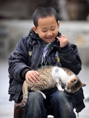 Zhu Xu plays with a cat at home in Xianfeng County in Enshi, central China&apos;s Hubei Province, October 11, 2009.