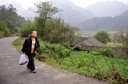 Zhu Xu is on his way to school in Xianfeng County in Enshi, central China&apos;s Hubei Province, October 11, 2009.