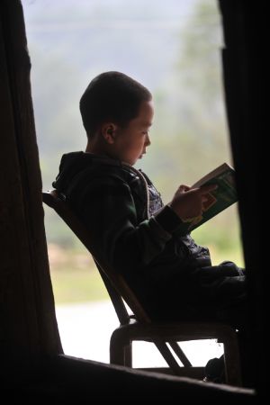 Zhu Xu reads a book at home in Xianfeng County in Enshi, central China&apos;s Hubei Province, October 11, 2009.