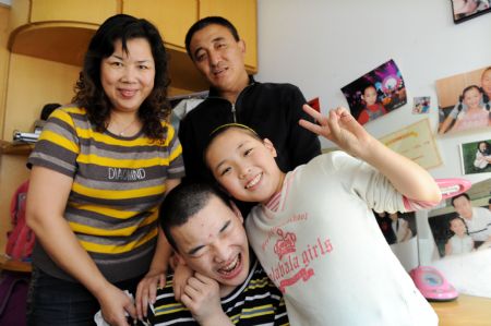 Liu Mengyi (R, front), holding her brother in her arm, has their family picture taken at their home in Qingdao, east China's Shandong Province, October 15, 2009.