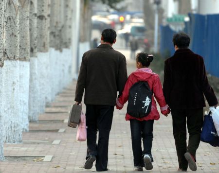 Liang Yuxin goes home with her grandparents after danced in the seniors' home in Harbin, capital of northeast China's Heilongjiang Province, October 27, 2009. 