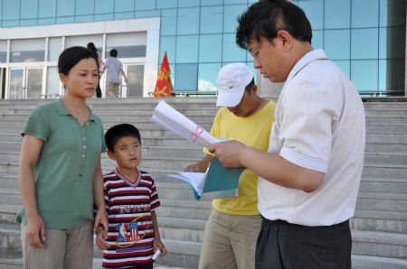 Liu Hao (2nd, L), an eight-year-old blind boy of a worker's family, listens to director's instruction during the shooting of a film narrating the story of his own, in Chifeng City, north China's Inner Mongolia Autonomous Region, January 6, 2008. 