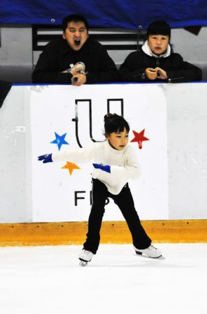 Zhang Mingyang skates as her parents watch in the ice stadium in Harbin, capital of northeast China's Heilongjiang Province, November 2, 2009. Her father Zhang Tianling yawns because it's too early in the morning.