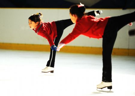 Zhang Mingyang (L) skates during morning exercises in Harbin, capital of northeast China's Heilongjiang Province, November 1, 2009. 