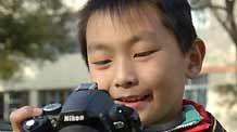 Chen Ming, a grade 5 pupil, reviews the photos he has just taken, on camera view frame, in Xining, capital of northwest China's Qianghai Province, October 30, 2009.