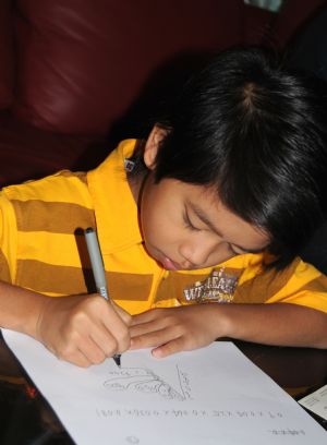 Adi Putra does calculations at home in Gombak District, Selangor State, Malaysia, on October 7, 2009.