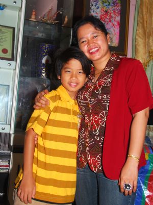 Adi Putra (L) poses for photos with his mother at home in Gombak District, Selangor State, Malaysia, on October 7, 2009. 