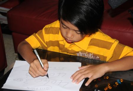 Adi Putra does calculations at home in Gombak District, Selangor State, Malaysia, on October 7, 2009.