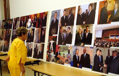 A woman views the displayed photos during a photo exhibition at the Chinese Embassy in Kampala, capital of Uganda, November 9, 2009.