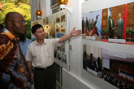 Yu Qiuzhong (R), Charge d'Affairs of China's Embassy to the Democratic Republic of Congo (DRC), briefs the exhibited photos to guests during a photo exhibition at the Chinese Embassy in Kinshasa, capital of DRC, November 9, 2009. The photo exhibition opened here on Monday, in a move to showcase the achievements of follow up actions of the Beijing Summit of the Forum on Sino-Africa Cooperation.