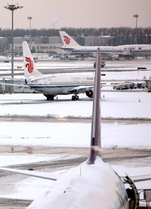 Planes are seen on the parking apron at Capital International Airport in Beijing, capital of China, November 10, 2009. Some flights were suspended due to the second snowfall this winter hitting Beijing early November 10.