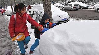 Two pupils play with snow in Beijing, capital of China, November 10, 2009. Beijing witnessed the second snowfall this winter on November 10.