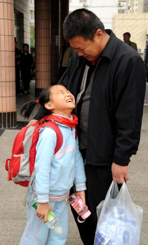 Fuqing, the eldest child of quintuplets children of Jiao Baocun and his wife Wang Cuiying, throws herself into her father's arms in Beijing on October 30, 2009. 