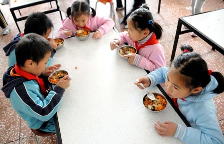 Quintuplets children of Jiao Baocun and his wife Wang Cuiying eat lunch together at Experimental Primary School of Fengtai District in Beijing on October 29, 2009.