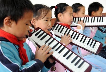 Quintuplets children of Jiao Baocun and his wife Wang Cuiying learn melodica together at Experimental Primary School of Fengtai District in Beijing on October 29, 2009.