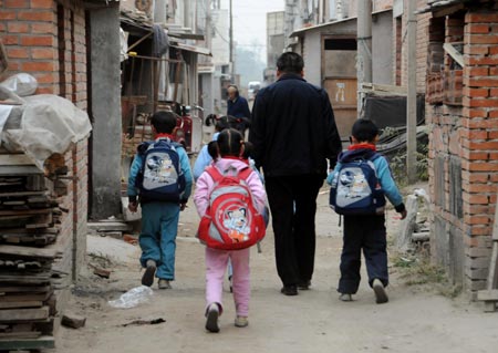 Quintuplets children of Jiao Baocun and his wife Wang Cuiying go home with their father in Beijing on October 30, 2009.