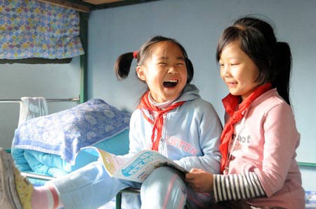 Fuqing (L), the eldest child of quintuplets children of Jiao Baocun and his wife Wang Cuiying, chats with her classmate in her dormitory at Experimental Primary School of Fengtai District in Beijing on October 29, 2009.