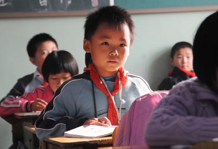 Fuyuan, the youngest child of quintuplets children of Jiao Baocun and his wife Wang Cuiying, listens carefully to the teacher in his class at Experimental Primary School of Fengtai District in Beijing on October 29, 2009.